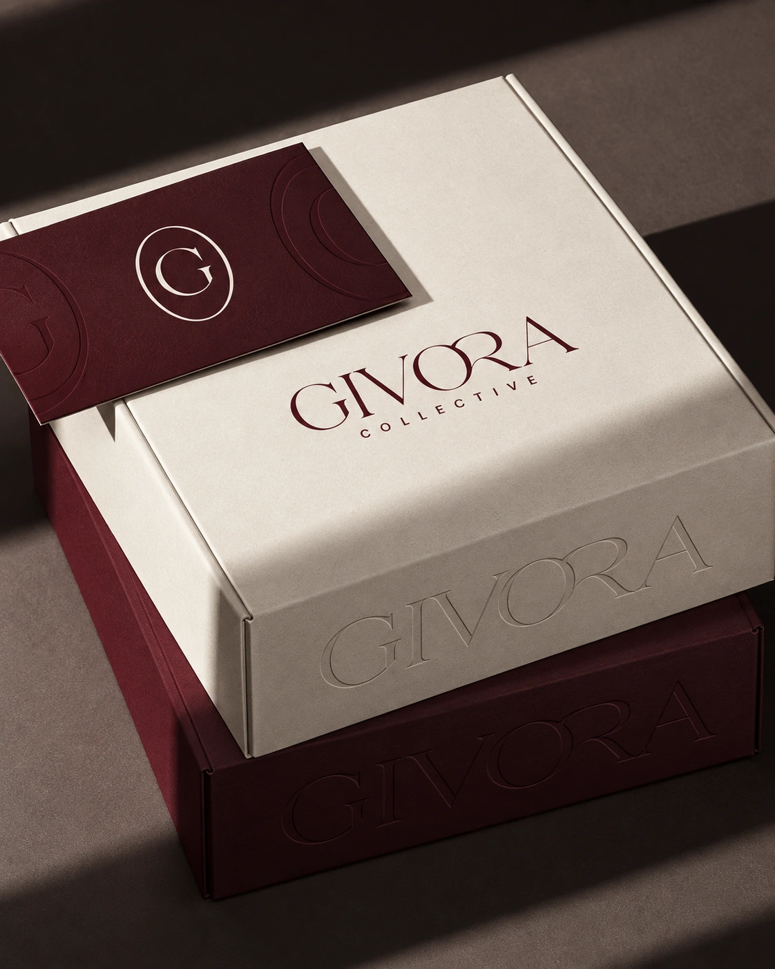 Stacked Ivory and Burgundy Givora packaging with embossed details
